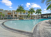 Thumbnail 50 of 65 - A large outdoor swimming pool surrounded by palm trees and lounge chairs. at Centre Pointe Apartments, Florida