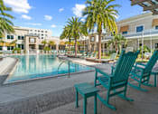 Thumbnail 52 of 65 - A pool area with a bench and chairs. at Centre Pointe Apartments, Melbourne