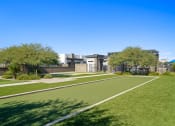 Thumbnail 30 of 33 - a park with grass and trees and buildings in the background at Olive Queen Creek Apartments, Queen Creek, Arizona
