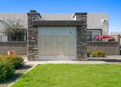 Thumbnail 28 of 33 - the front of a building with a garage door and a lawn at Olive Queen Creek Apartments, Arizona, 85142