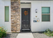 Thumbnail 18 of 33 - a front door of a house with a wreath on it at Olive Queen Creek Apartments, Queen Creek, AZ