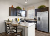 Thumbnail 1 of 36 - a kitchen with stainless steel appliances and a counter with bar stools at Bella Grace, Chandler, Arizona