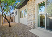 Thumbnail 19 of 36 - a patio with a tree and a white house with glass doors at Bella Grace, Arizona, 85225