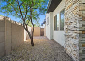 Thumbnail 20 of 36 - a courtyard with a tree and a stone wall at Bella Grace, Chandler