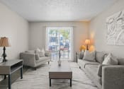 Thumbnail 8 of 24 - a living room with couches and a coffee table and a balcony