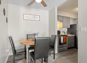 Thumbnail 7 of 24 - a dining area with a table and chairs and a kitchen