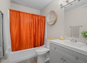 Thumbnail 15 of 24 - a bathroom with an orange shower curtain and a toilet and a sink