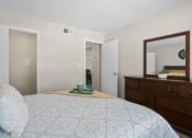 Thumbnail 13 of 24 - a bedroom with a bed and a dresser and a mirror