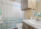 Thumbnail 13 of 29 - bathroom with brown cabinets, white sink and toilet