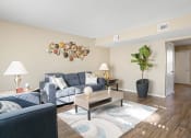 Thumbnail 3 of 29 - living room with blue couch, brown table and plant