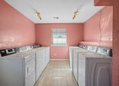 Thumbnail 21 of 29 - washers and dryers in room with window and pink walls