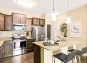 Thumbnail 1 of 49 - a kitchen with stainless steel appliances and a granite countertop at Skye at Arbor Lakes, Maple Grove, Minnesota