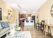 Thumbnail 5 of 49 - a living room and kitchen with a large clock on the wall at Skye at Arbor Lakes Apartments, Maple Grove, MN