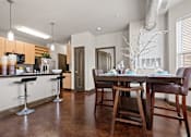 Thumbnail 4 of 34 - an open kitchen and dining room with a table and chairs at The Millennium Towne Center Apartments, Baton Rouge, LA
