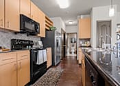 Thumbnail 1 of 34 - a kitchen with stainless steel appliances and wooden cabinets at The Millennium Towne Center Apartments, Baton Rouge