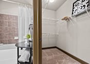 Thumbnail 14 of 34 - a bathroom with a shower and a tub and a table at The Millennium Towne Center Apartments, Baton Rouge