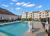 Thumbnail 3 of 33 - a swimming pool with apartment buildings in the background at The Landing Apartment , Hazlet, NJ