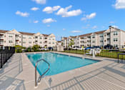 Thumbnail 2 of 33 - a swimming pool with an apartment building in the background at The Landing Apartment , Hazlet