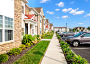 Thumbnail 25 of 33 - a row of houses with cars parked in front of them at The Landing Apartment , Hazlet