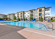 Thumbnail 34 of 48 - a swimming pool with an apartment building in the background