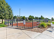 Thumbnail 42 of 48 - a park with a tennis court and a bench in front of a fence