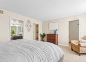 Thumbnail 18 of 40 - a bedroom with a bed and a chair and a closet at Silver Reef Apartments, Lakewood, 80228