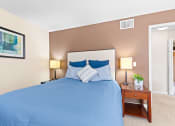 Thumbnail 9 of 40 - the master bedroom has a large bed and a nightstand with a plant at Silver Reef Apartments, Lakewood, Colorado