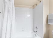 Thumbnail 15 of 40 - a bathroom with a shower and a tub and a sink at Silver Reef Apartments, Lakewood, 80228