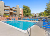 Thumbnail 28 of 40 - our apartments have a resort style pool with blue lounge chairs at Silver Reef Apartments, Lakewood, Colorado