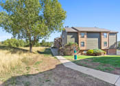 Thumbnail 39 of 40 - a house with a sidewalk and trees in front of it at Silver Reef Apartments, Lakewood, 80228