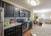 Thumbnail 1 of 38 - a kitchen with granite counter tops and black cabinets at 150 Summit, Birmingham, AL, 35243