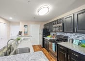 Thumbnail 2 of 38 - a kitchen with black appliances and granite counter tops at 150 Summit, Birmingham, Alabama