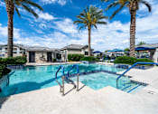 Thumbnail 13 of 15 - A swimming pool surrounded by palm trees and residential houses. at Vistoria At Country Place Apartments, Arizona, 85353