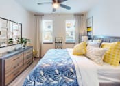 Thumbnail 21 of 65 - A bedroom with a bed, dresser, and ceiling fan. at Centre Pointe Apartments, Florida, 32940