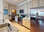 Thumbnail 18 of 65 - A modern kitchen with a stainless steel refrigerator and wooden cabinets. at Centre Pointe Apartments, Melbourne, Florida