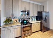 Thumbnail 19 of 65 - A modern kitchen with wooden cabinets and stainless steel appliances. at Centre Pointe Apartments, Melbourne, FL