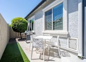 Thumbnail 9 of 15 - A patio with a table and chairs is set up outside a house at Vistoria At Marley Park Apartments, Surprise, AZ, 85379