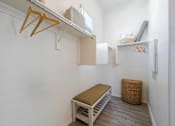 Thumbnail 6 of 15 - A small room with a bed, a bench, and a small refrigerator. at Vistoria At Marley Park Apartments, Surprise, 85379