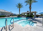 Thumbnail 14 of 15 - A pool with a diving board and palm trees in the background at Vistoria At Marley Park Apartments, Surprise, Arizona