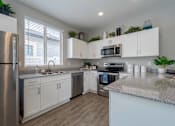 Thumbnail 1 of 15 - A kitchen with white cabinets and a granite countertop. at Vistoria At Stadium Apartments, Glendale, AZ, 85305