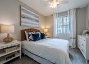 Thumbnail 6 of 15 - A bedroom with a large bed, a ceiling fan, and a painting on the wall. at Vistoria At Stadium Apartments, Arizona