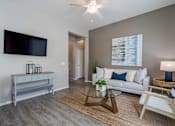 Thumbnail 3 of 15 - A living room with a white couch, a television, and a coffee table. at Vistoria At Stadium Apartments, Glendale, AZ, 85305