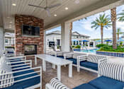 Thumbnail 13 of 15 - A patio with white furniture and a brick fireplace. at Vistoria At Stadium Apartments, Glendale, 85305