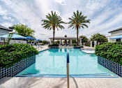 Thumbnail 11 of 15 - A swimming pool surrounded by palm trees and a blue sky. at Vistoria At Stadium Apartments, Glendale, AZ, 85305