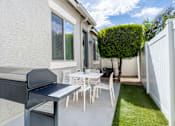 Thumbnail 11 of 15 - A white patio with a table and chairs. at Vistoria At Country Place Apartments, Tolleson, AZ, 85353
