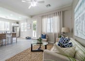 Thumbnail 3 of 15 - A well-lit living room with a couch, chairs, and a dining table. at Vistoria At Country Place Apartments, Tolleson, Arizona
