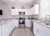 Thumbnail 2 of 15 - A modern kitchen with white cabinets and stainless steel appliances. at Vistoria At Country Place Apartments, Tolleson
