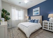 Thumbnail 6 of 15 - A bedroom with a large bed, a nightstand, and a window with curtains. at Vistoria At Country Place Apartments, Tolleson, AZ, 85353