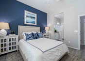 Thumbnail 7 of 15 - A bedroom with a white bed and blue accents. at Vistoria At Country Place Apartments, Tolleson, AZ, 85353