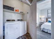 Thumbnail 8 of 15 - A small laundry room with a washer and dryer.